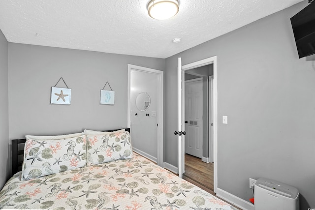 6001-1732 S Kings Hwy, Myrtle Beach, SC 29575 - bedroom featuring wood finished floors, baseboards, and a textured ceiling