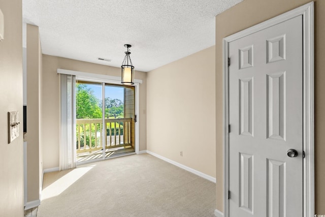 carpeted empty room with baseboards and a textured ceiling