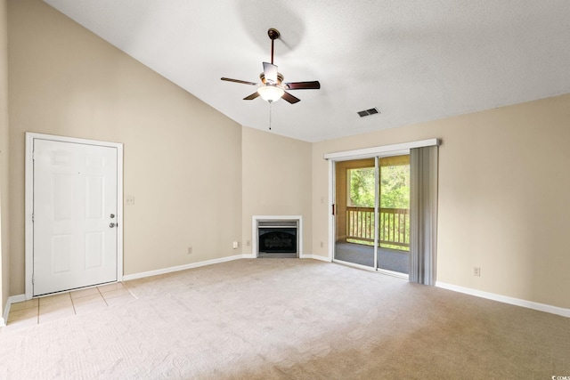 unfurnished living room with light carpet, a ceiling fan, baseboards, a fireplace, and vaulted ceiling
