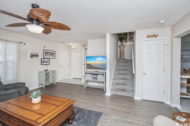 404 1st Ave N Unit H, North Myrtle Beach, SC 29582 - living area featuring a textured ceiling, ceiling fan, baseboards, and stairs