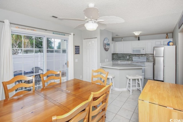 404 1st Ave N Unit H, North Myrtle Beach, SC 29582 - dining area with light tile patterned floors, a textured ceiling, and ceiling fan