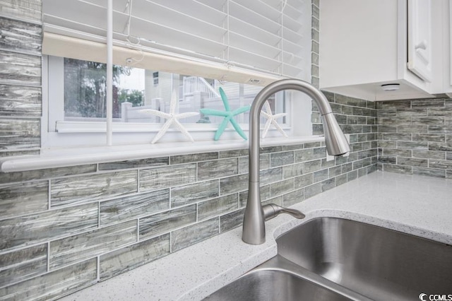 404 1st Ave N Unit H, North Myrtle Beach, SC 29582 - kitchen view of decorative backsplash, light stone counters, white cabinetry, and a sink
