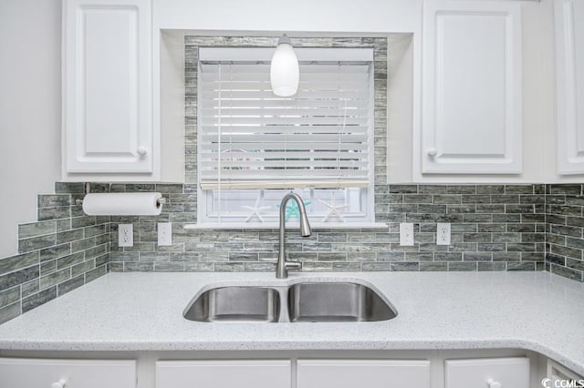 404 1st Ave N Unit H, North Myrtle Beach, SC 29582 - kitchen featuring a sink, white cabinetry, decorative backsplash, and light stone countertops