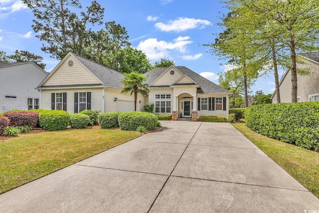 67 Camden Cir, Pawleys Island, SC 29585 - view of front of house featuring an attached garage, a front yard, and concrete driveway
