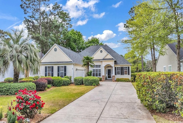 67 Camden Cir, Pawleys Island, SC 29585 - view of front of property with an attached garage, a front yard, a shingled roof, and driveway