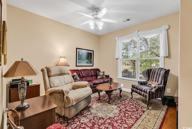 living area featuring ceiling fan, wood finished floors, and baseboards