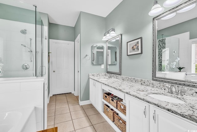 full bathroom with a stall shower, tile patterned flooring, double vanity, and baseboards