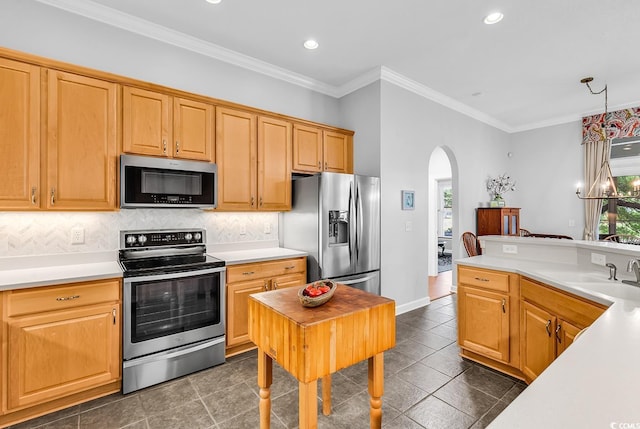 kitchen with appliances with stainless steel finishes, arched walkways, a sink, light countertops, and backsplash