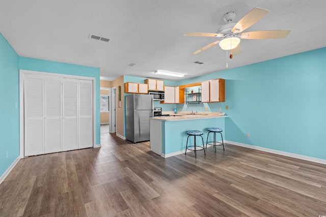 510 Fairwood Lakes Dr Unit 19-Q, Myrtle Beach, SC 29588 - kitchen featuring appliances with stainless steel finishes, a peninsula, dark wood finished floors, and a textured ceiling