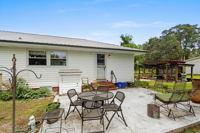 view of patio featuring entry steps, a grill, outdoor dining space, and a pergola