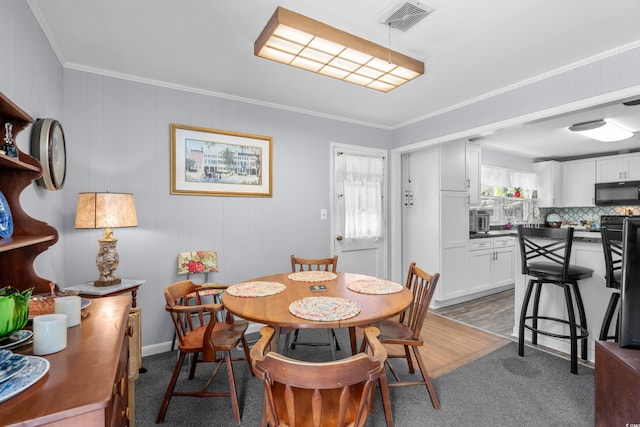 dining room with carpet and crown molding