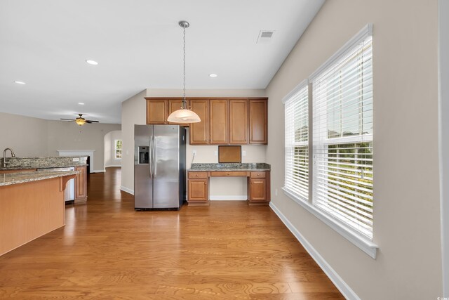 644 Harbor Bay Dr, Murrells Inlet, SC 29576 - kitchen with appliances with stainless steel finishes, light wood-style floors, hanging light fixtures, light stone counters, and baseboards