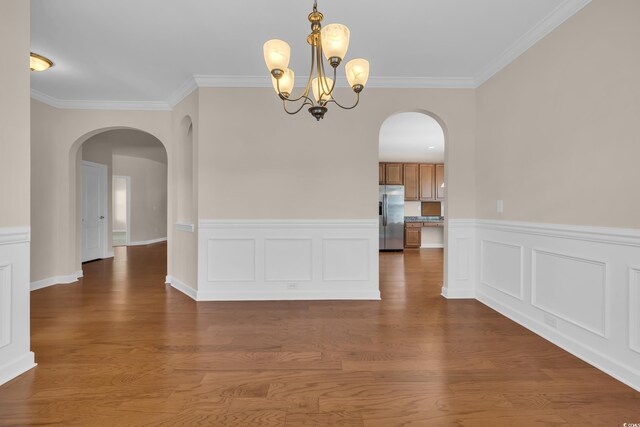 644 Harbor Bay Dr, Murrells Inlet, SC 29576 - unfurnished dining area featuring arched walkways, a chandelier, crown molding, wainscoting, and wood finished floors