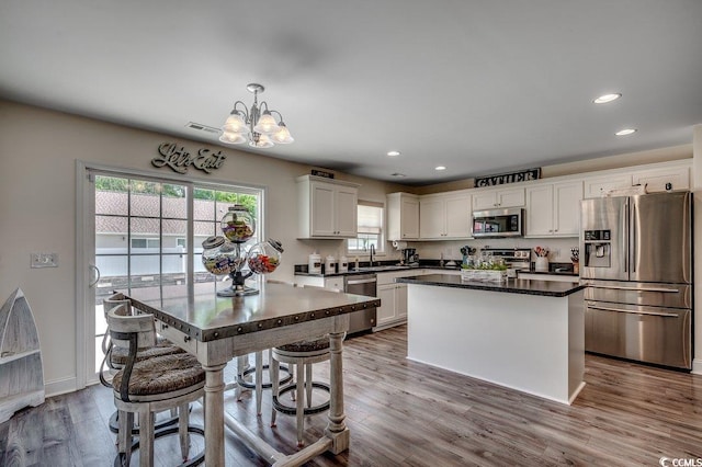 kitchen with appliances with stainless steel finishes, a chandelier, a sink, dark countertops, and recessed lighting