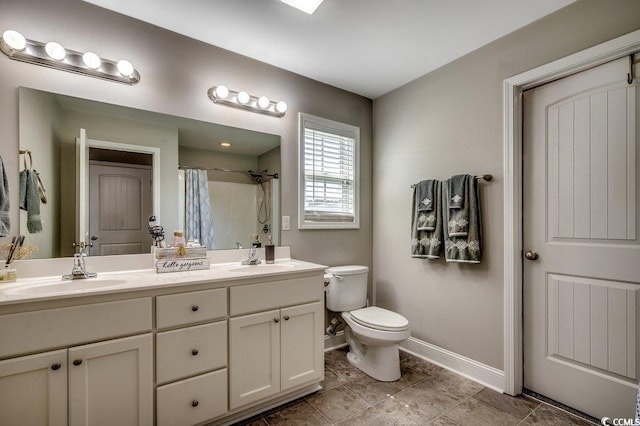 bathroom with baseboards, toilet, a shower with shower curtain, and double vanity
