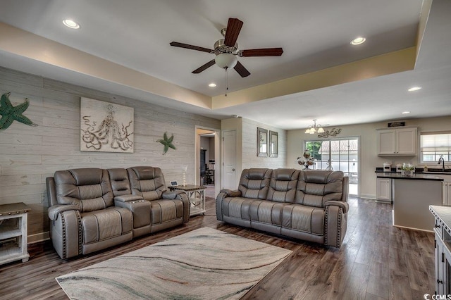 living area with ceiling fan, recessed lighting, a chandelier, dark wood-style flooring, and wood walls