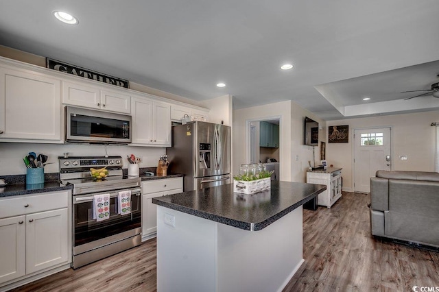 kitchen featuring stainless steel appliances, white cabinetry, light wood finished floors, open floor plan, and a center island