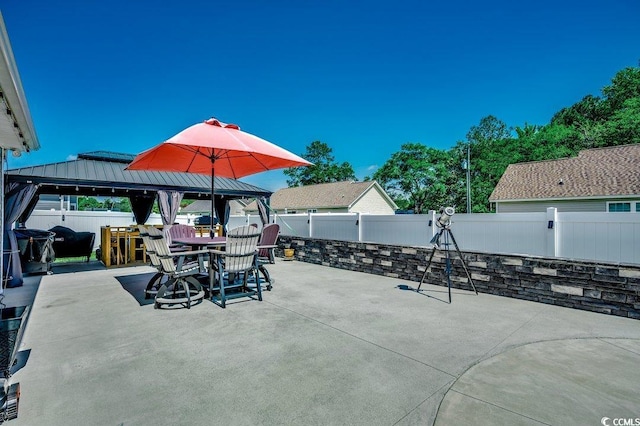 view of patio / terrace with a gazebo, a fenced backyard, and outdoor dining space