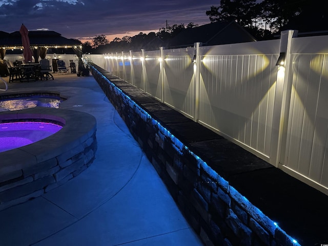 view of pool with an in-ground hot tub, a gazebo, fence, and a patio area