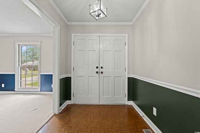 entryway featuring baseboards and crown molding