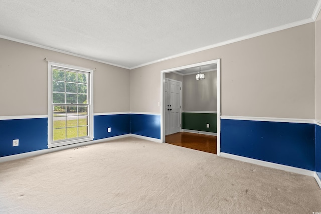 carpeted empty room with ornamental molding, a textured ceiling, and baseboards