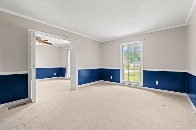 carpeted spare room featuring ornamental molding, a textured ceiling, and baseboards