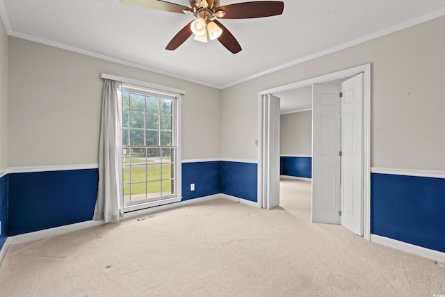 unfurnished bedroom with carpet floors, ornamental molding, baseboards, and a ceiling fan