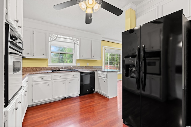 kitchen featuring black appliances, a sink, ceiling fan, ornamental molding, and dark wood-type flooring