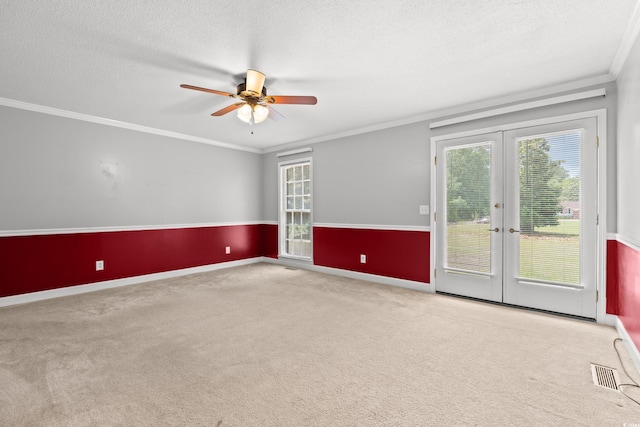 empty room featuring french doors, carpet flooring, ceiling fan, crown molding, and a textured ceiling