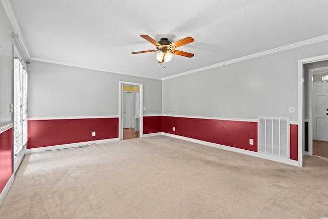 empty room with carpet, a ceiling fan, crown molding, and baseboards