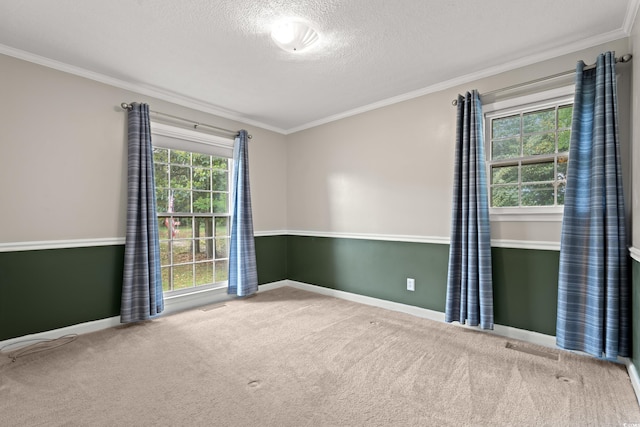 carpeted spare room featuring crown molding, a textured ceiling, and baseboards