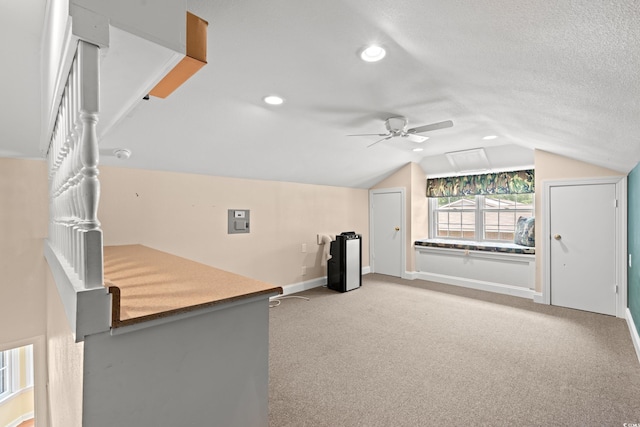 bonus room featuring ceiling fan, electric panel, vaulted ceiling, carpet floors, and baseboards