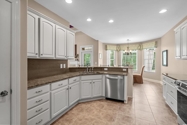 kitchen with appliances with stainless steel finishes, a sink, white cabinetry, a peninsula, and recessed lighting