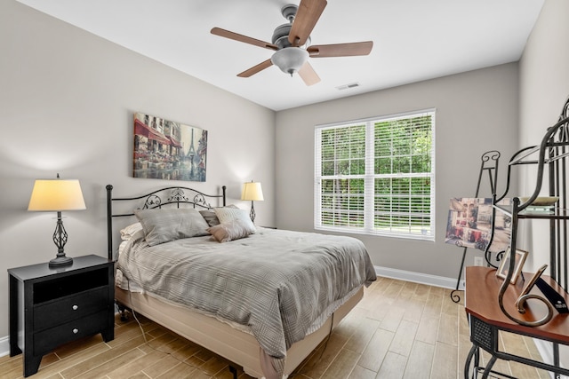 bedroom with light wood-style flooring, baseboards, and ceiling fan