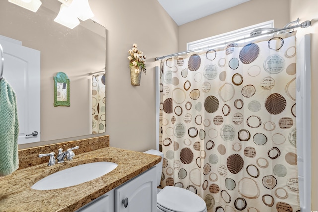 bathroom with toilet, vanity, and a shower with shower curtain