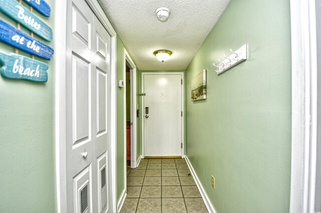 5905 S Kings Hwy Unit 116B, Myrtle Beach, SC 29575 - doorway with a textured ceiling, light tile patterned flooring, and baseboards