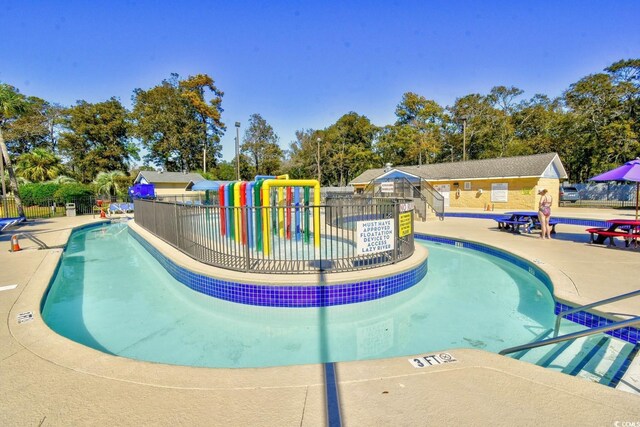 5905 S Kings Hwy Unit 116B, Myrtle Beach, SC 29575 - community pool with fence, a water play area, a patio, and view of wooded area