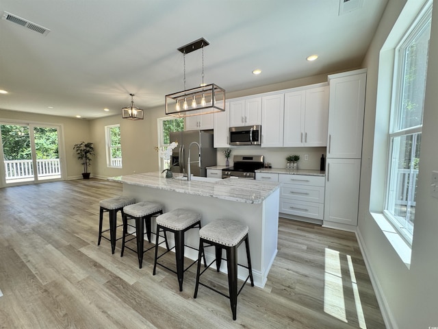 1673 Carriage Ln, Little River, SC 29566 - kitchen with stainless steel appliances, a breakfast bar area, baseboards, an island with sink, and recessed lighting
