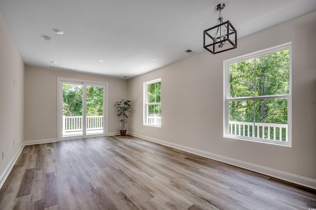 1673 Carriage Ln, Little River, SC 29566 - spare room with a chandelier, wood finished floors, and healthy amount of natural light