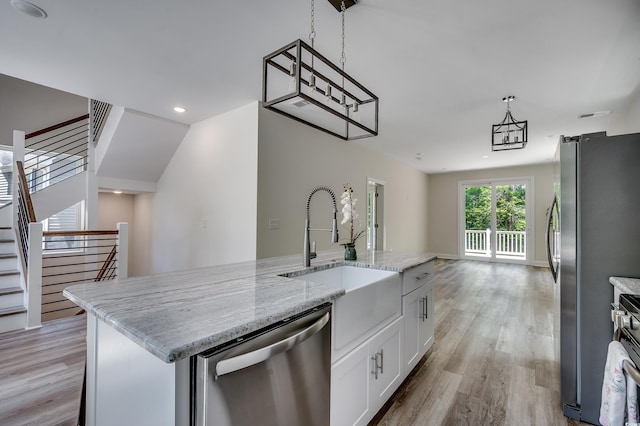 1673 Carriage Ln, Little River, SC 29566 - kitchen featuring dishwasher, light wood-type flooring, a sink, white cabinets, and light stone counters