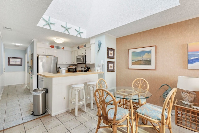 210 N Ocean Blvd Unit 333, North Myrtle Beach, SC 29582 - dining space featuring a textured ceiling, light tile patterned floors, and ornamental molding