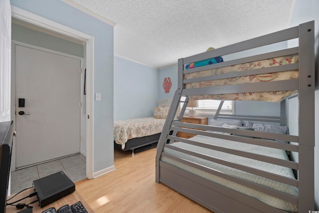 210 N Ocean Blvd Unit 333, North Myrtle Beach, SC 29582 - bedroom with crown molding, light wood-type flooring, and a textured ceiling