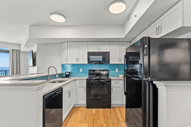 3000 N Ocean Blvd N Unit 1401, Myrtle Beach, SC 29577 - kitchen with black appliances, a sink, a peninsula, light countertops, and light wood-type flooring