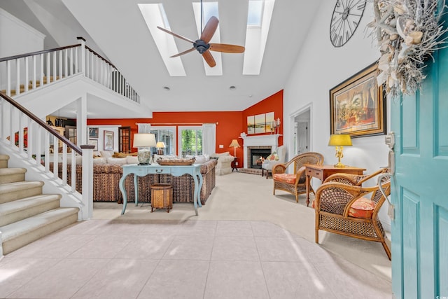 444 Dornoch Dr, Pawleys Island, SC 29585 - carpeted living room featuring high vaulted ceiling, a skylight, stairs, a brick fireplace, and tile patterned flooring