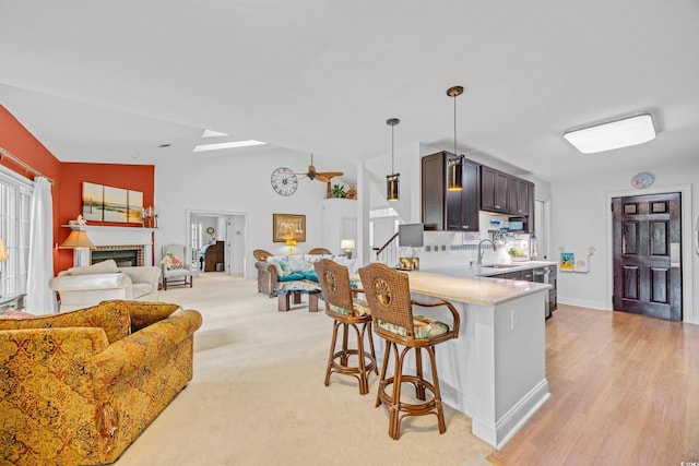 444 Dornoch Dr, Pawleys Island, SC 29585 - kitchen with light countertops, a kitchen breakfast bar, a sink, open floor plan, and dark brown cabinetry