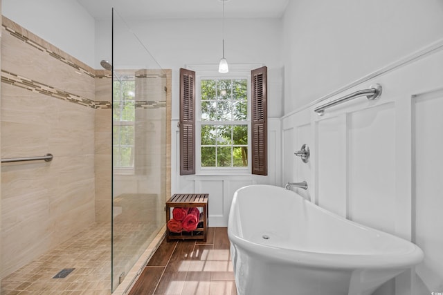 444 Dornoch Dr, Pawleys Island, SC 29585 - bathroom with a soaking tub, wood finished floors, a tile shower, a decorative wall, and wainscoting