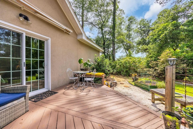 444 Dornoch Dr, Pawleys Island, SC 29585 - wooden terrace with outdoor dining space, a garden, and view of scattered trees