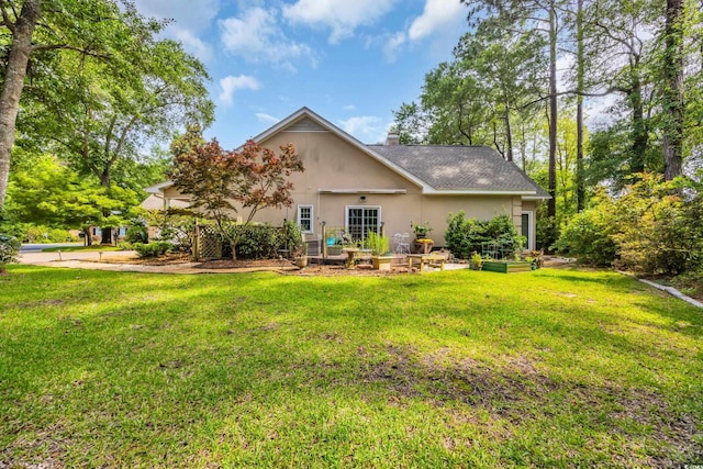444 Dornoch Dr, Pawleys Island, SC 29585 - back of house featuring stucco siding, a lawn, a vegetable garden, and a chimney
