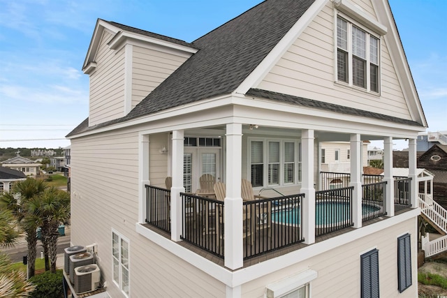 703 S Waccamaw Dr, Garden City Beach, SC 29576 - view of side of home featuring a shingled roof, central AC unit, and fence