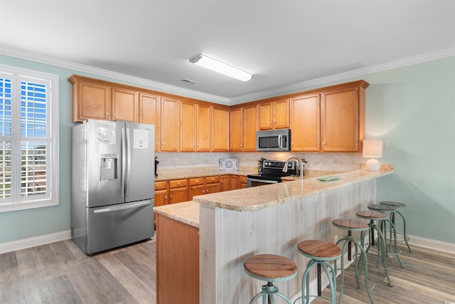 703 S Waccamaw Dr, Garden City Beach, SC 29576 - kitchen with appliances with stainless steel finishes, a peninsula, decorative backsplash, baseboards, and a kitchen breakfast bar